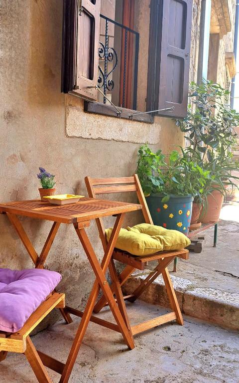 a wooden table and two chairs sitting next to a building at Apartment Zlatko in Šibenik