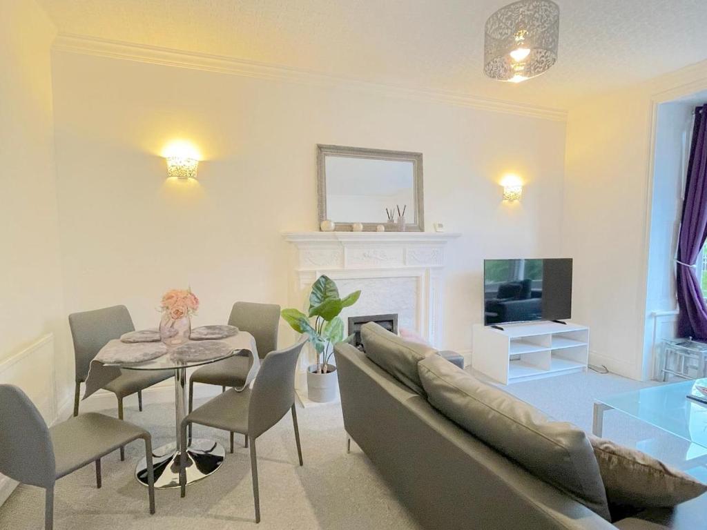 sala de estar con sofá, mesa y TV en Luxury Apartment in Paddington, en Londres