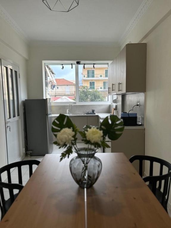 a vase of flowers on a wooden table in a kitchen at Mary Lo Guest House in Nydri