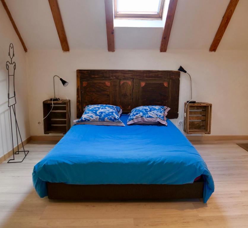 a bedroom with a large bed with a blue comforter at grande Cahute in Soultzmatt
