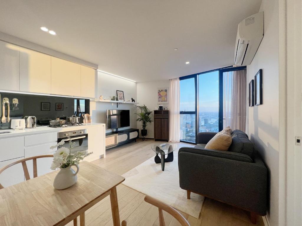 a kitchen and living room with a couch and a table at Sky View 1B1B APT in the CBD in Melbourne