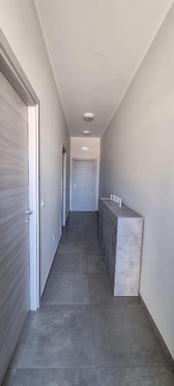 un couloir vide menant à une porte dans l'établissement Room's Stromboli, à San Ferdinando