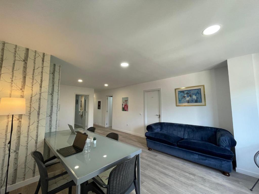 a living room with a blue couch and a table at CoLiving El Juanito in Las Palmas de Gran Canaria