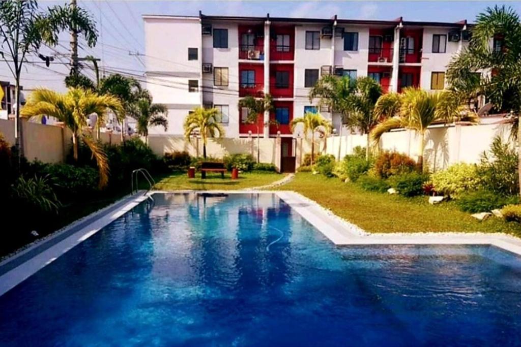 a large swimming pool in front of a building at Elegant 2BR Hampton Suites with Pool & WiFi in Anabu Primero