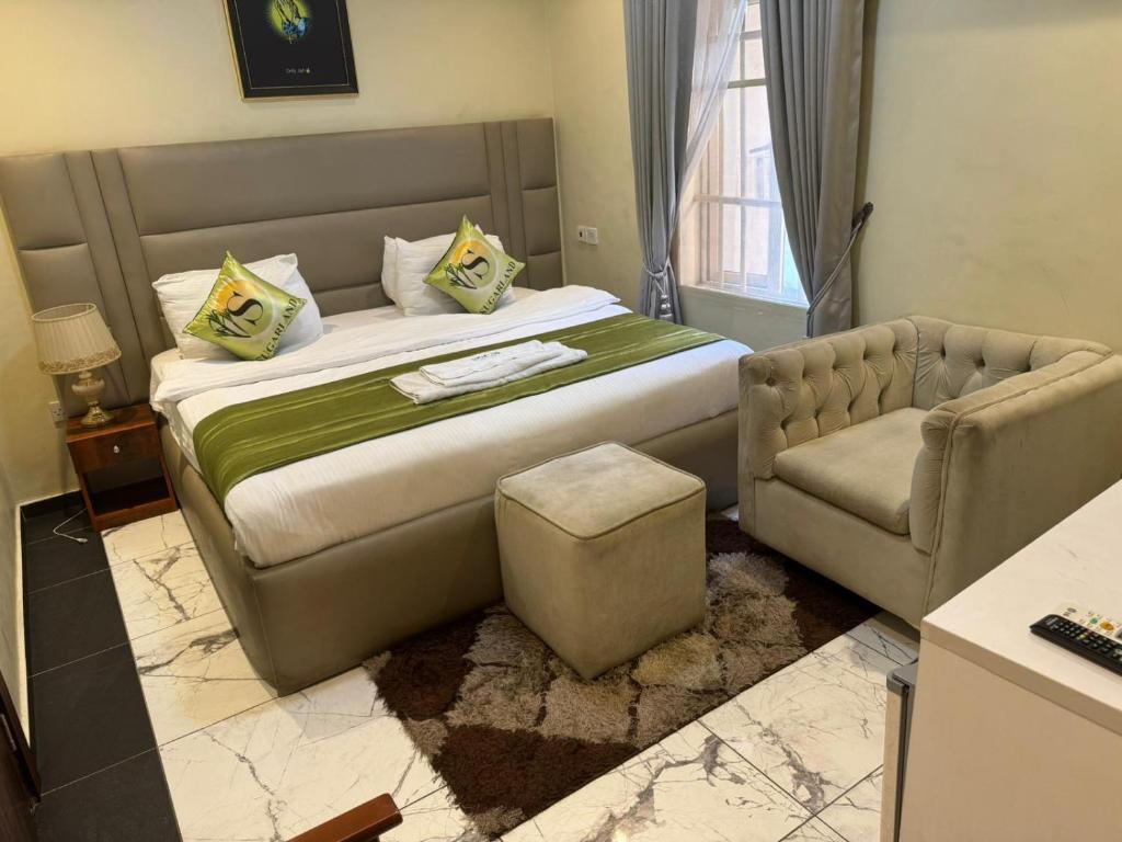 1 dormitorio con 1 cama grande y 1 sofá en Sugarland Hotel and Suite, en Ikeja