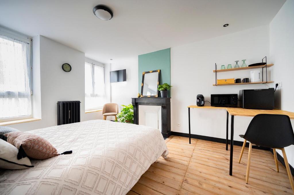 een slaapkamer met een bed, een bureau en een tafel bij Élégante chambre avec salle de douche privative in Montivilliers