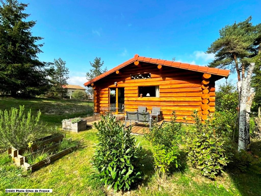 uma cabana de madeira com um alpendre num campo em Pialous:Chalet en rondins avec Espace Détente em La Chapelle-dʼAurec