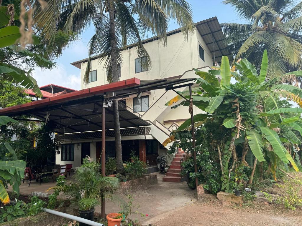 una casa con palmeras delante en KENSON'S INN, en Mangalore