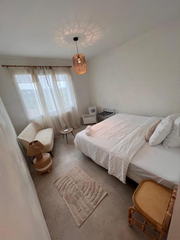 1 dormitorio con 1 cama, 1 silla y 1 lámpara de araña en Demeure du Mas de Bessac, en Brengues