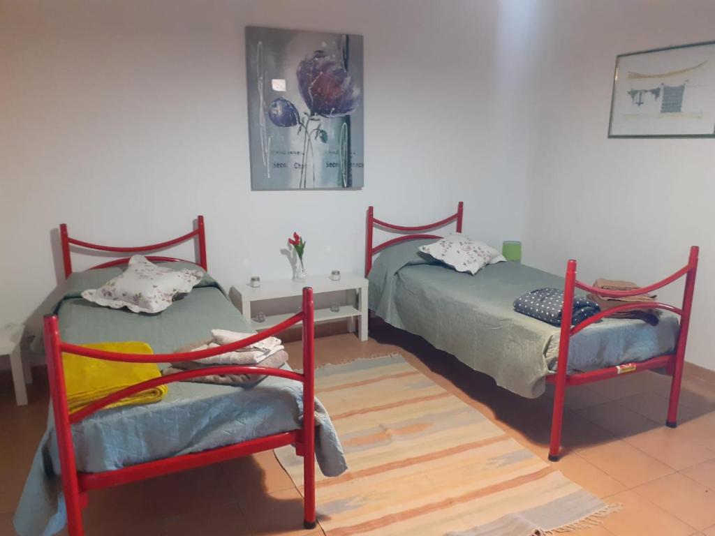 una camera da letto con due letti e un tavolo di Casa Vacanza L'ulivo a Paterno