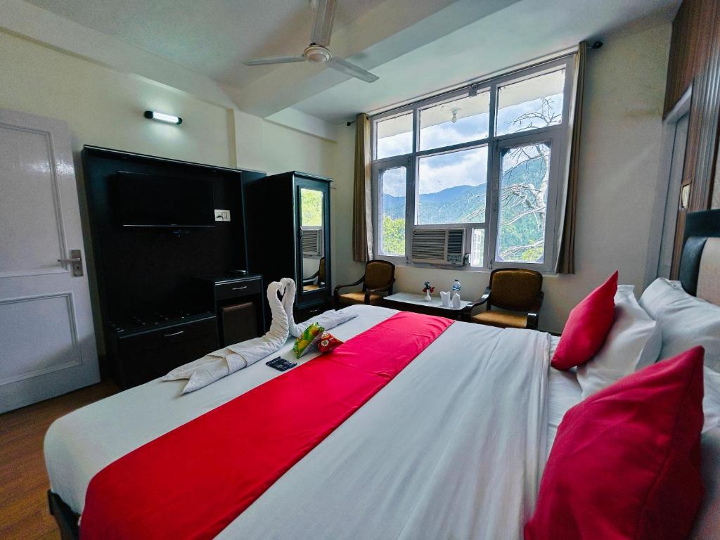 a bedroom with a large bed with a red blanket at Hotel Eagle Nest Central Heated in Dalhousie