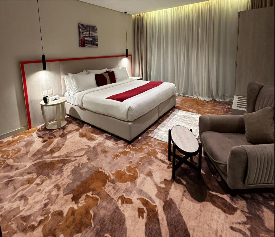um quarto de hotel com uma cama grande e um sofá em Jardin an em Abha