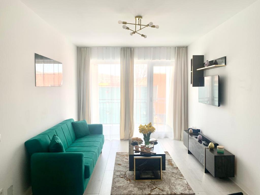 Apartament 1 camera في Sancraiu de Mures: غرفة معيشة مع أريكة خضراء أمام نافذة
