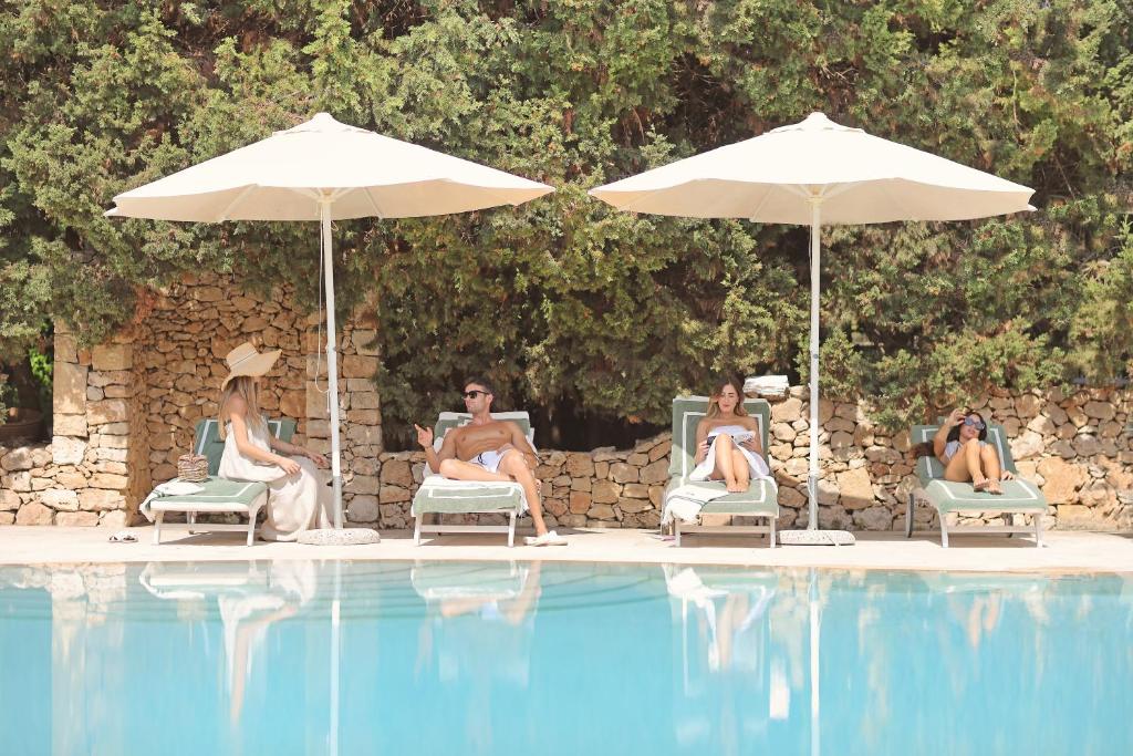 un grupo de mujeres sentadas en sillas junto a una piscina en Maison D'Enrì, en Gallipoli