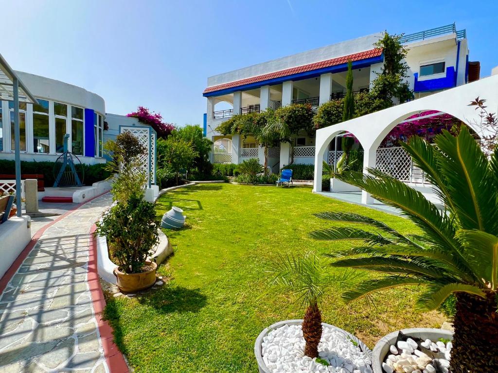 un cortile con un prato con piante e un edificio di SCALA APARTS & STUDIOS - Rhodes a Afantou
