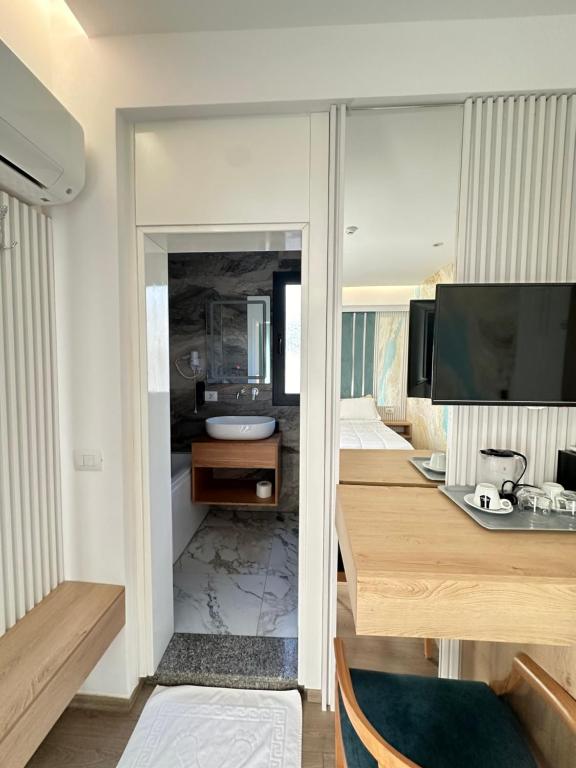 a bedroom with a desk and a bed with a television at Ilio Boutique Hotel in Ksamil