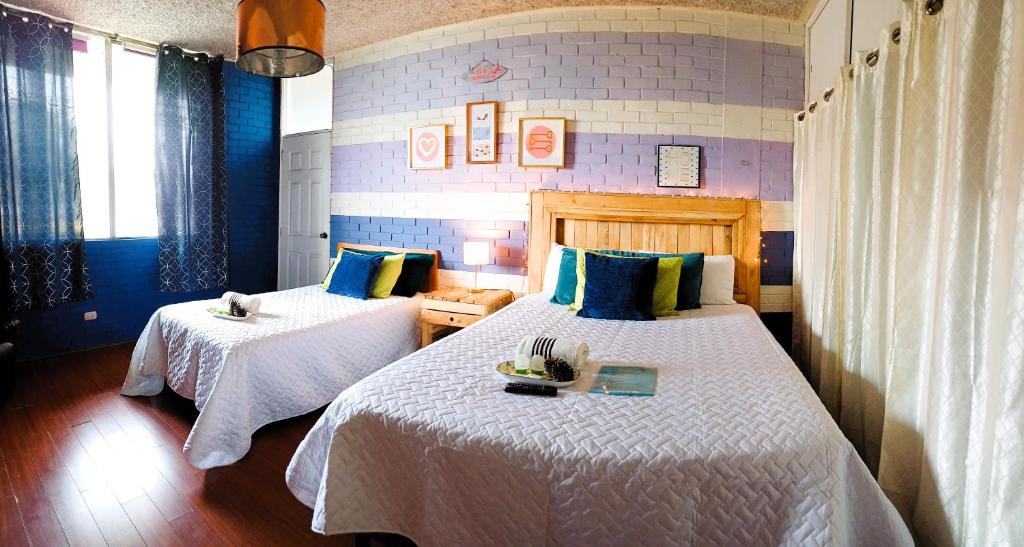 危地馬拉的住宿－Hostal de Lucca，一间卧室配有两张带白色床单的床
