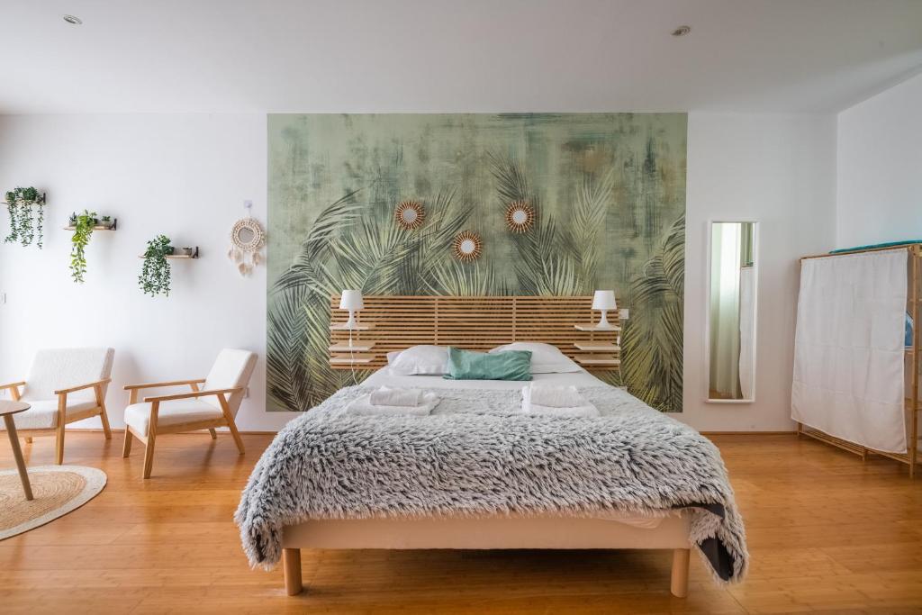 une chambre avec un lit et un tableau au mur dans l'établissement Le Bambou: Grand studio au calme, Climatisé, 5 min de la Gare, à Bordeaux