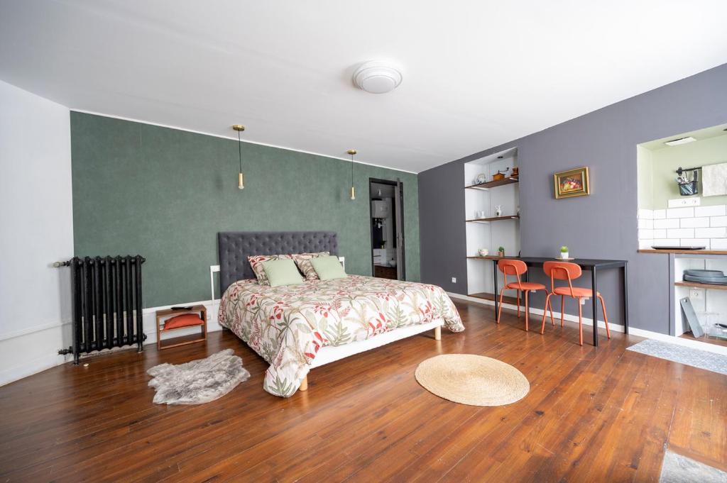 um quarto com uma cama, uma mesa e cadeiras em Appartement spacieux et élégant avec jardin em Montivilliers