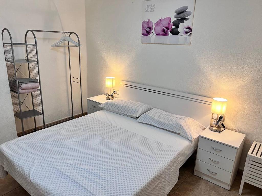 バレンシアにあるPlaza Sainetero Arnichesのベッドルーム1室(白いベッド1台、2つの照明付)