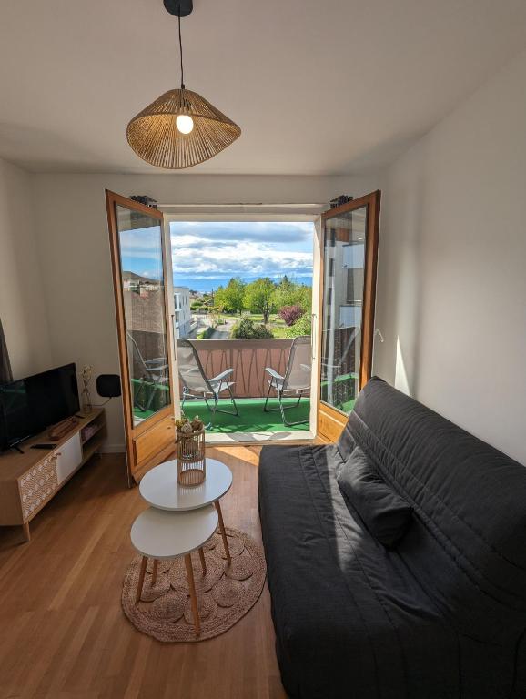 un salon avec un canapé et une table dans l'établissement Cosy et moderne avec Clim - Lac Léman, à Thonon-les-Bains