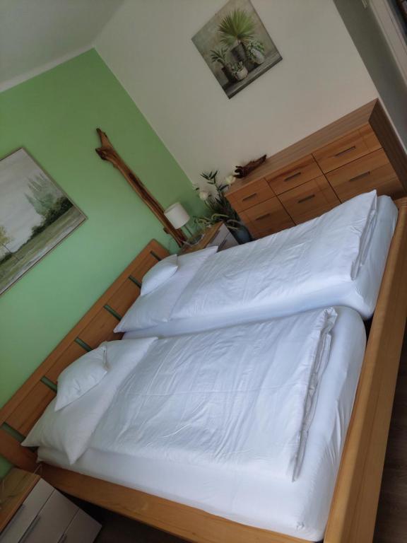 een slaapkamer met een bed met witte lakens bij Wohnung mit Charme in Pinsdorf in Pinsdorf