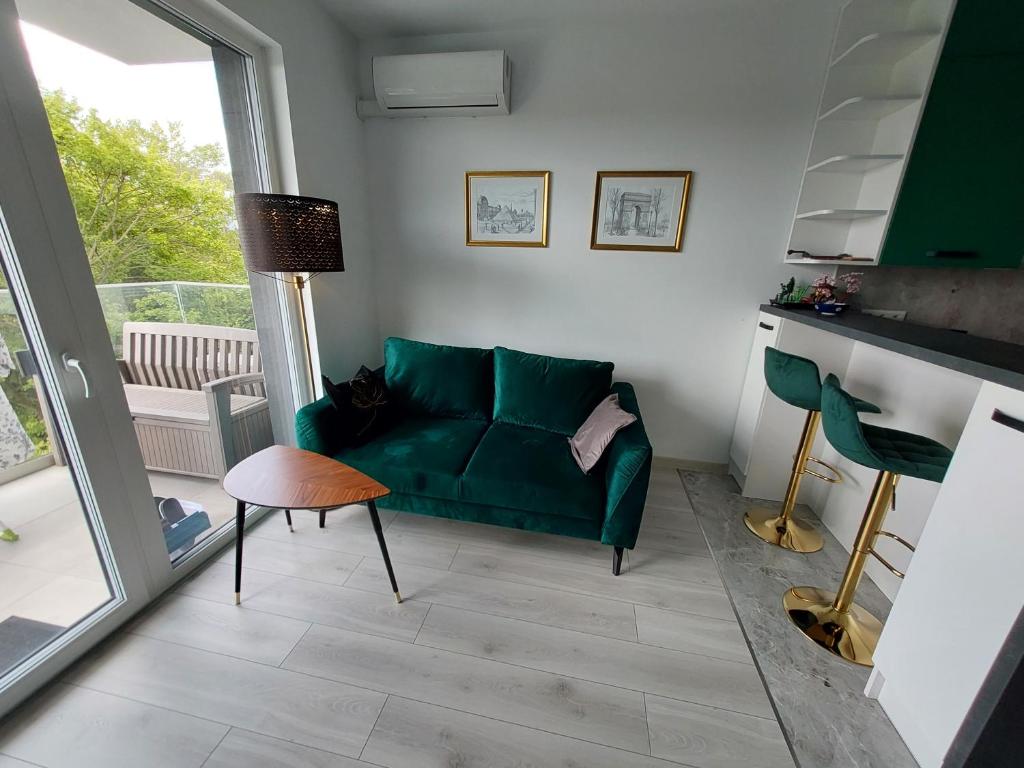 salon z zieloną kanapą i stołem w obiekcie Krapkowice Odrzańskie Tarasy w mieście Krapkowice