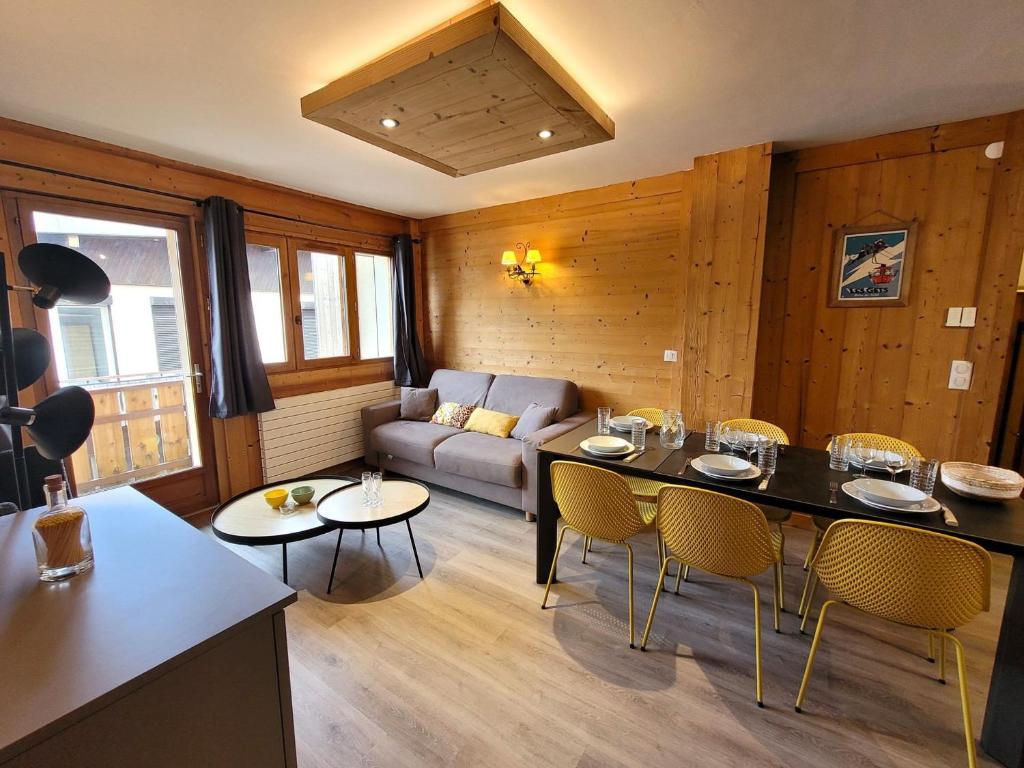 ein Wohnzimmer mit einem Sofa, einem Tisch und Stühlen in der Unterkunft Appartement Les Gets, 3 pièces, 6 personnes - FR-1-598-76 in Les Gets