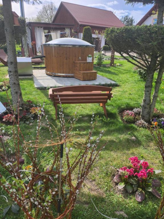 a park bench in a yard with a gazebo at Liwa Garden Krzywa 11 in Liwa