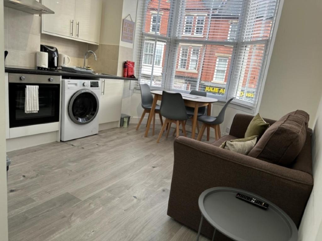 a kitchen and living room with a couch and a table at Central Colwyn Bay Studio Flat 2A in Colwyn Bay