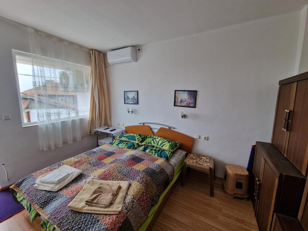 Habitación pequeña con cama y ventana en Къща за гости Пантови, en Grammatikovo