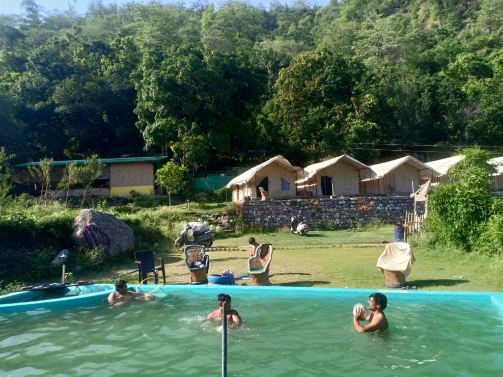 a group of people in the water in a swimming pool at Gurgaon Paradise Resort Tapovan, Rishikesh in Rishīkesh