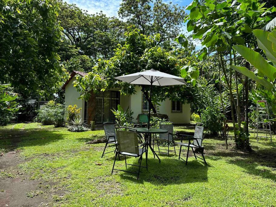 uma mesa e cadeiras com um guarda-sol num quintal em Cabaña/casa Wolf 