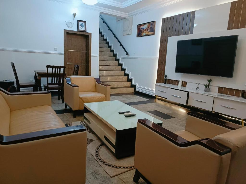 a living room with couches and a flat screen tv at The Breeze Apartment in Ikeja