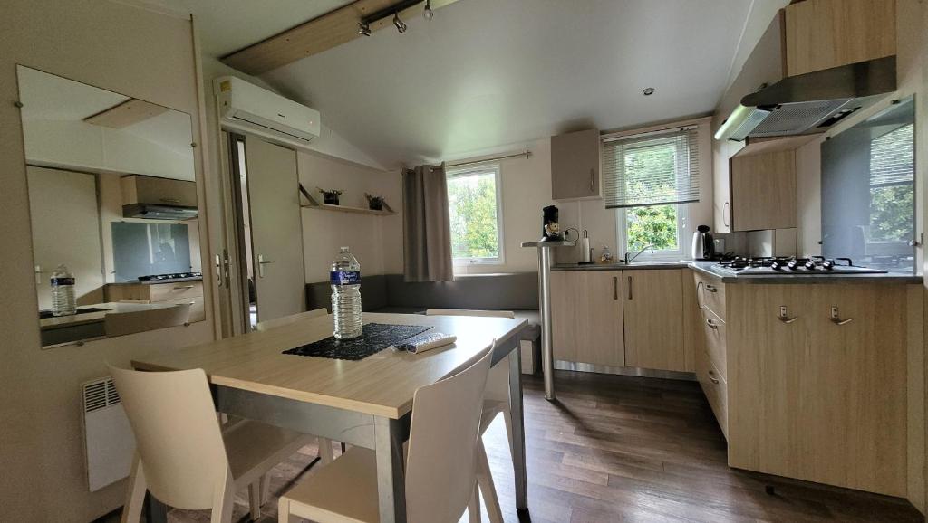 a kitchen with a wooden table with a bottle of water on it at MobilHome Marie EUROPAPARK 20min in Boofzheim
