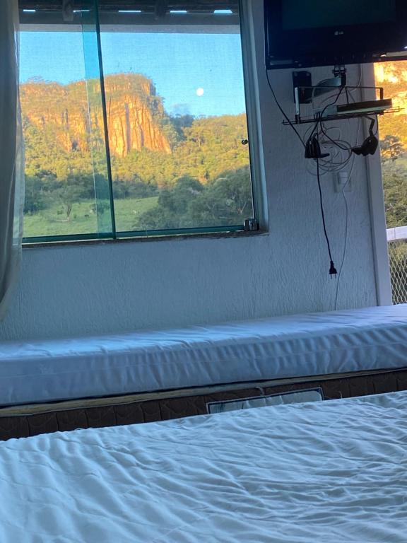 um quarto com uma cama e uma janela com vista em Paraiso na beira de cachoeiras Canyons Capitólio MG em Guapé