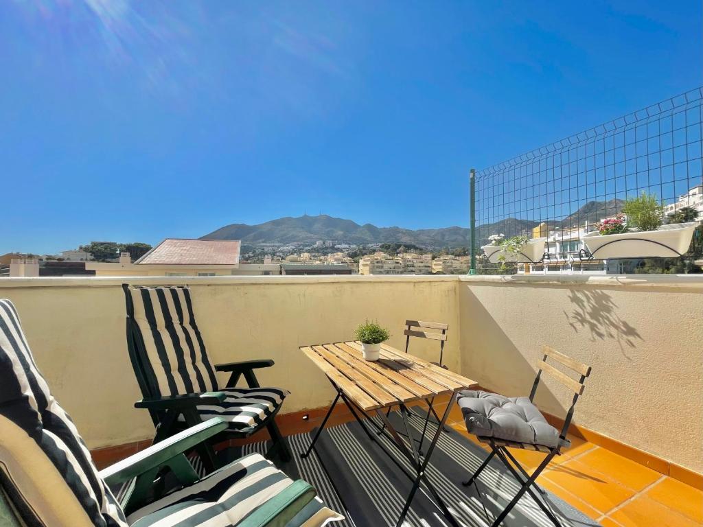 een balkon met 2 stoelen en een tafel op een dak bij LaFrenchTouch - Torrequebrada 2dorm cerca playa in Benalmádena