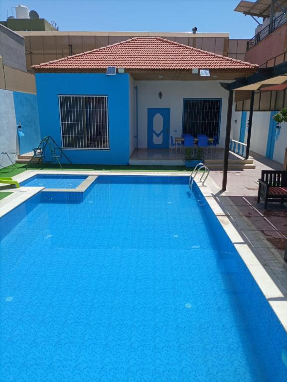 a swimming pool in front of a house at Julie Home Chalet in Madaba