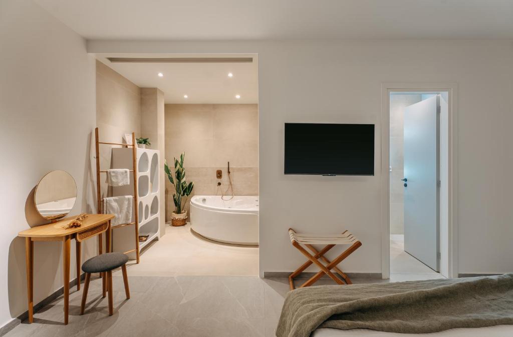 1 dormitorio con baño con bañera y TV en Trizonia Mare Suites, en Trizonia