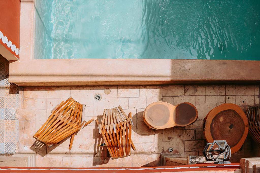 uma piscina com utensílios de madeira numa parede em Hotel Quinta Marciala MX em Valladolid