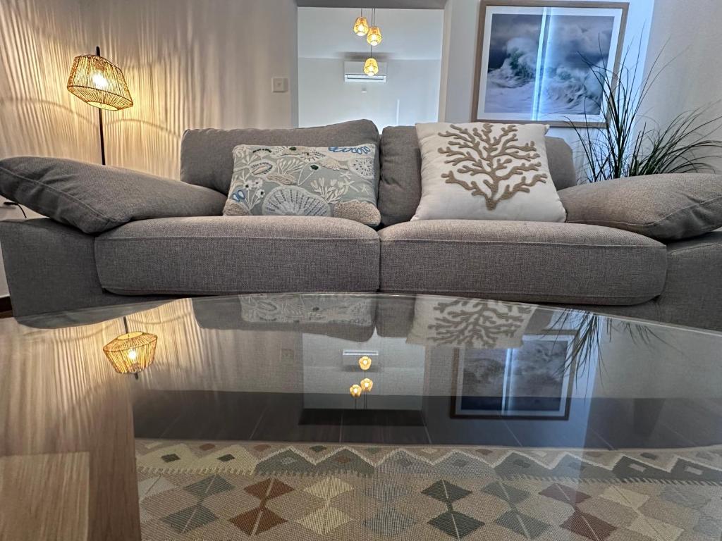 a living room with a couch and a glass table at The Beach House in Birżebbuġa