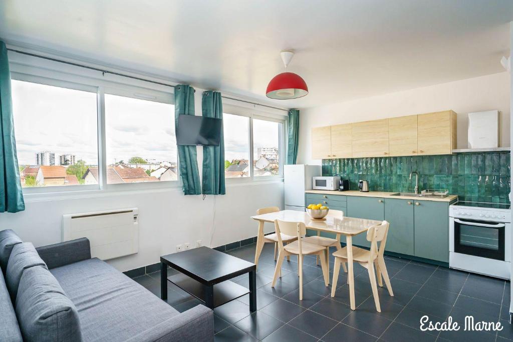 a living room with a couch and a table at Escale-marne fr - 202 - Free Parking - Free Luggage Storage - Metro 8 Eiffel Tower - All equipped - Linen Included - Washing Machine - Panoramic View - From 1 to 18 guests in Maisons-Alfort