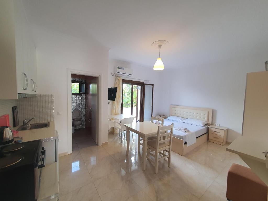 a kitchen and a living room with a bed and a table at Mihal Suites in Sarandë