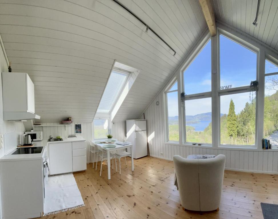 a kitchen and dining room with large windows at Fjord road in Hjelmeland