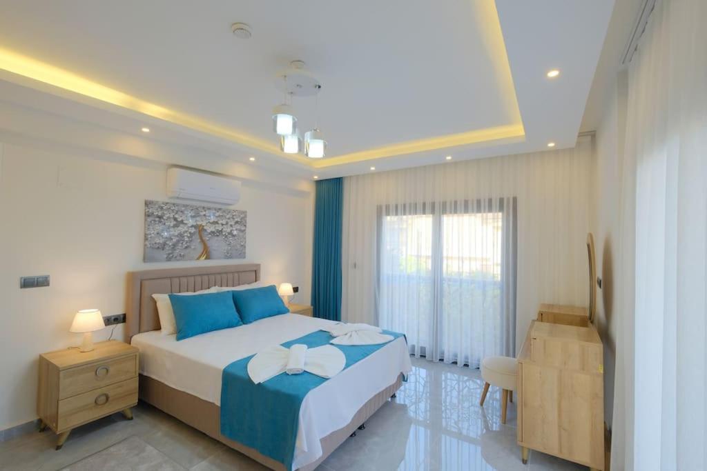 Un dormitorio con una cama grande con almohadas azules. en Villa Erika 1, en Fethiye
