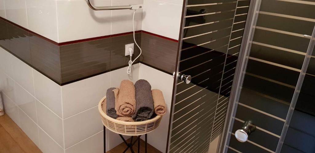 een rieten mand met handdoeken in de badkamer bij Domki Pod Lasem in Macharce