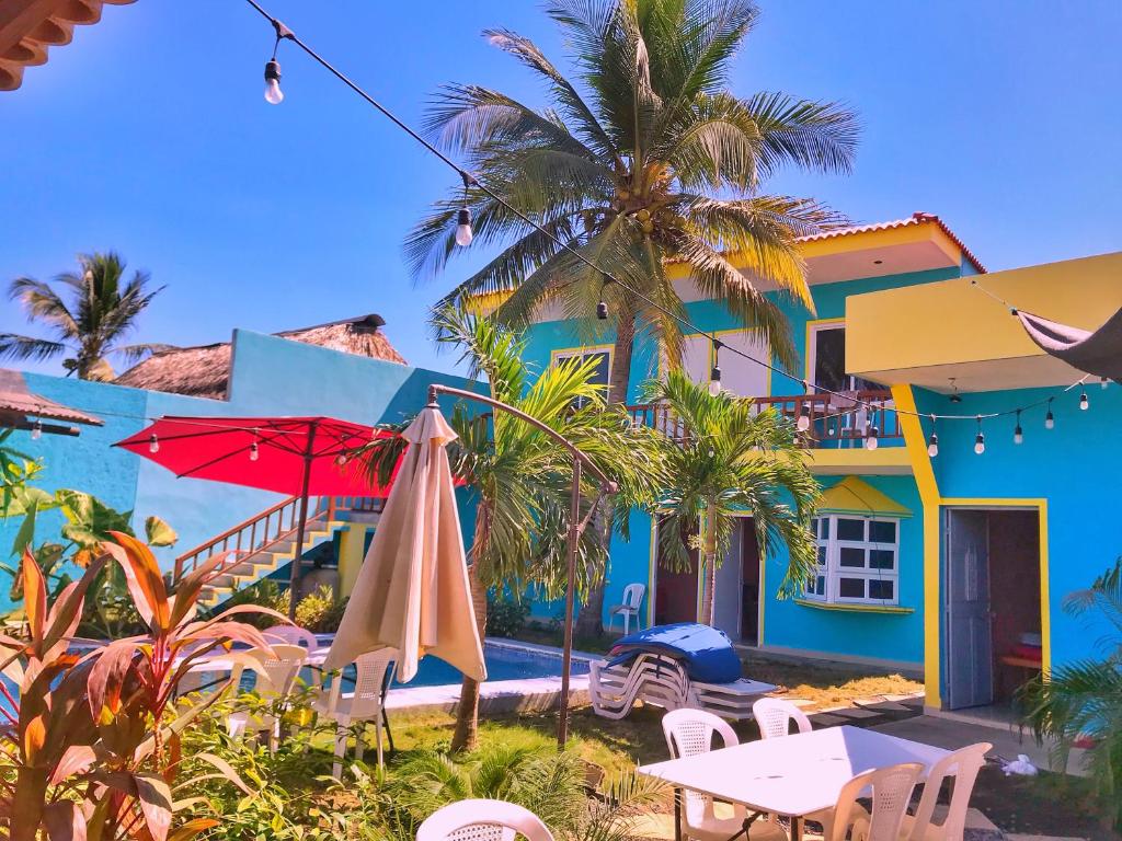una casa colorata con tavolo e ombrellone di Hotel el Paredon a El Paredón Buena Vista