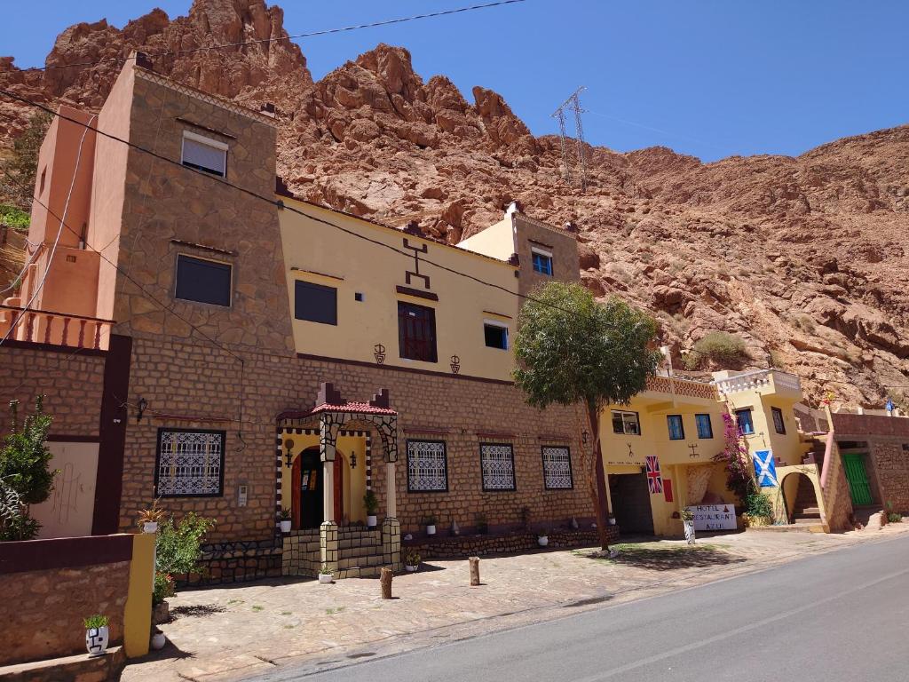 a building on the side of a street with a mountain at Hotel AZUL Todra Gorges in Tinerhir