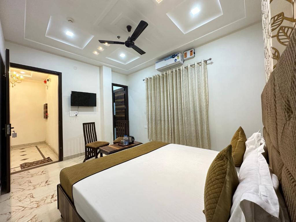 Embasy Hotel Near Golden Temple في أمريتسار: غرفة نوم بسرير وطاولة مع كرسي