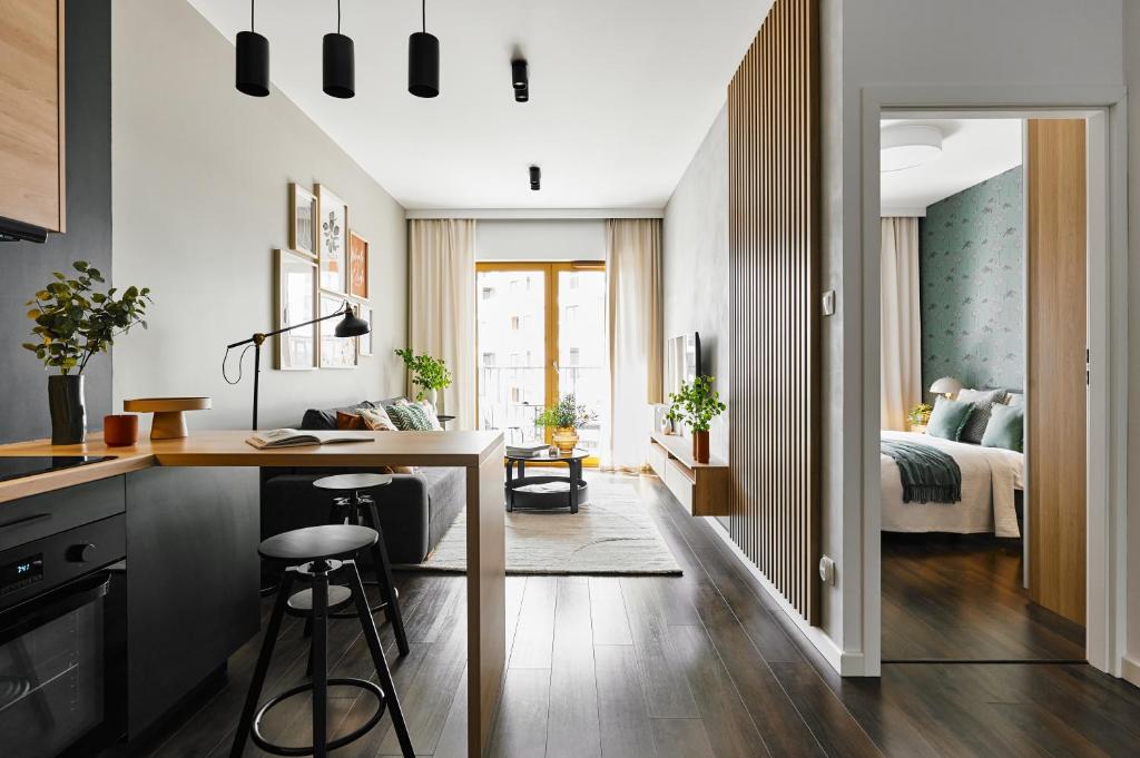a kitchen and living room with a bed in a bedroom at Cracow Palm Apartment in Kraków